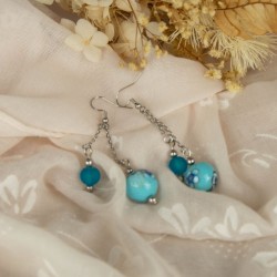 Un duo de perles, entre verre et polymère fleuri – tout en contraste et en harmonie.